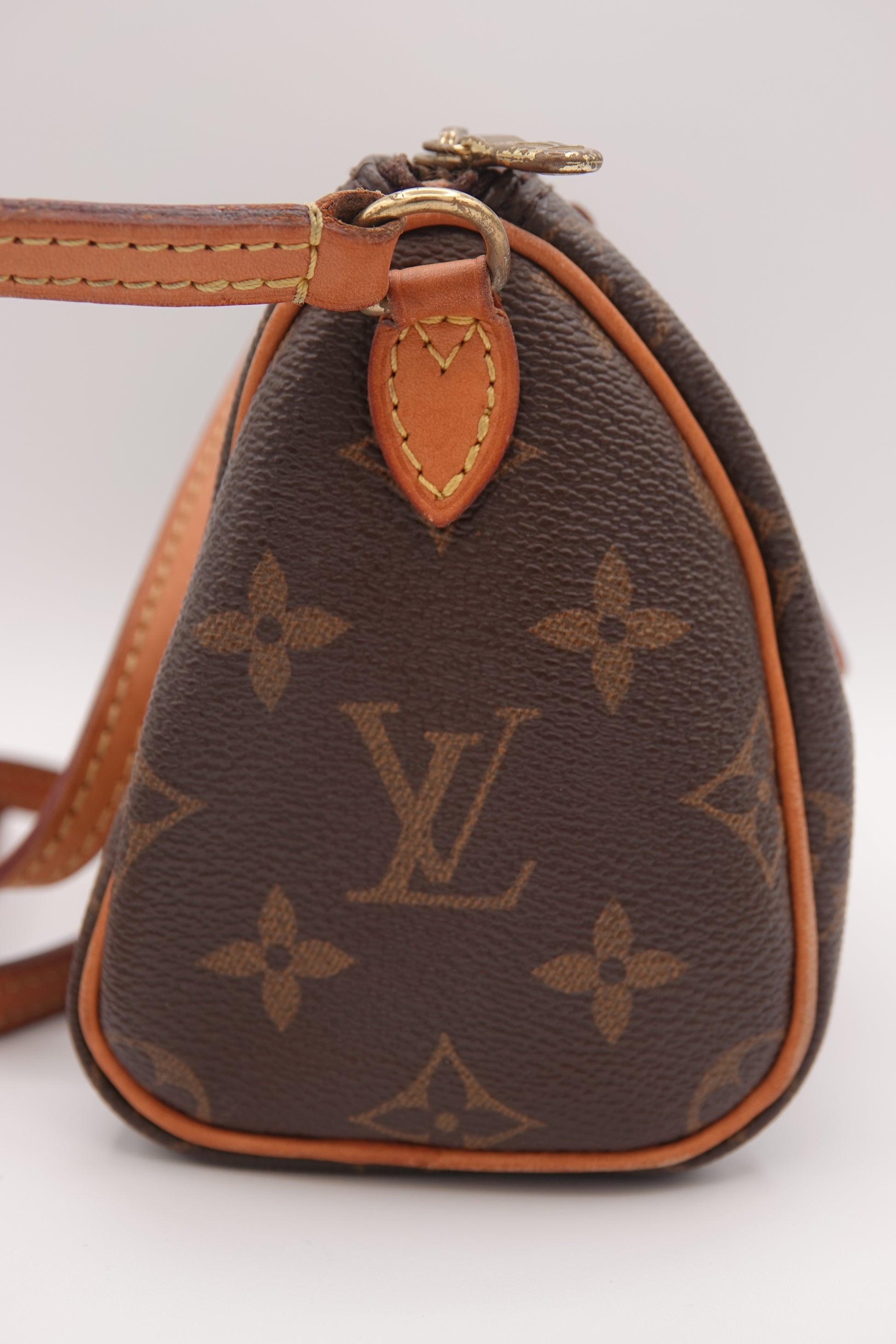 Brown handbag with monogram pattern on a white background