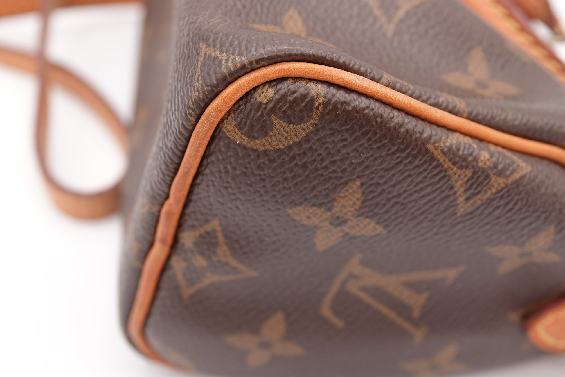 Close-up of a brown leather handbag with a distinctive pattern on a white background
