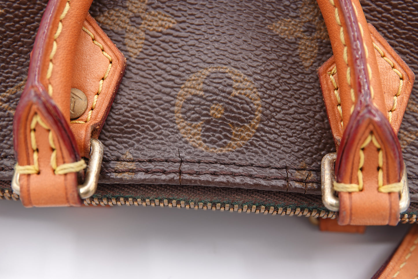 Close-up of a brown handbag with visible brand logo and leather handles.