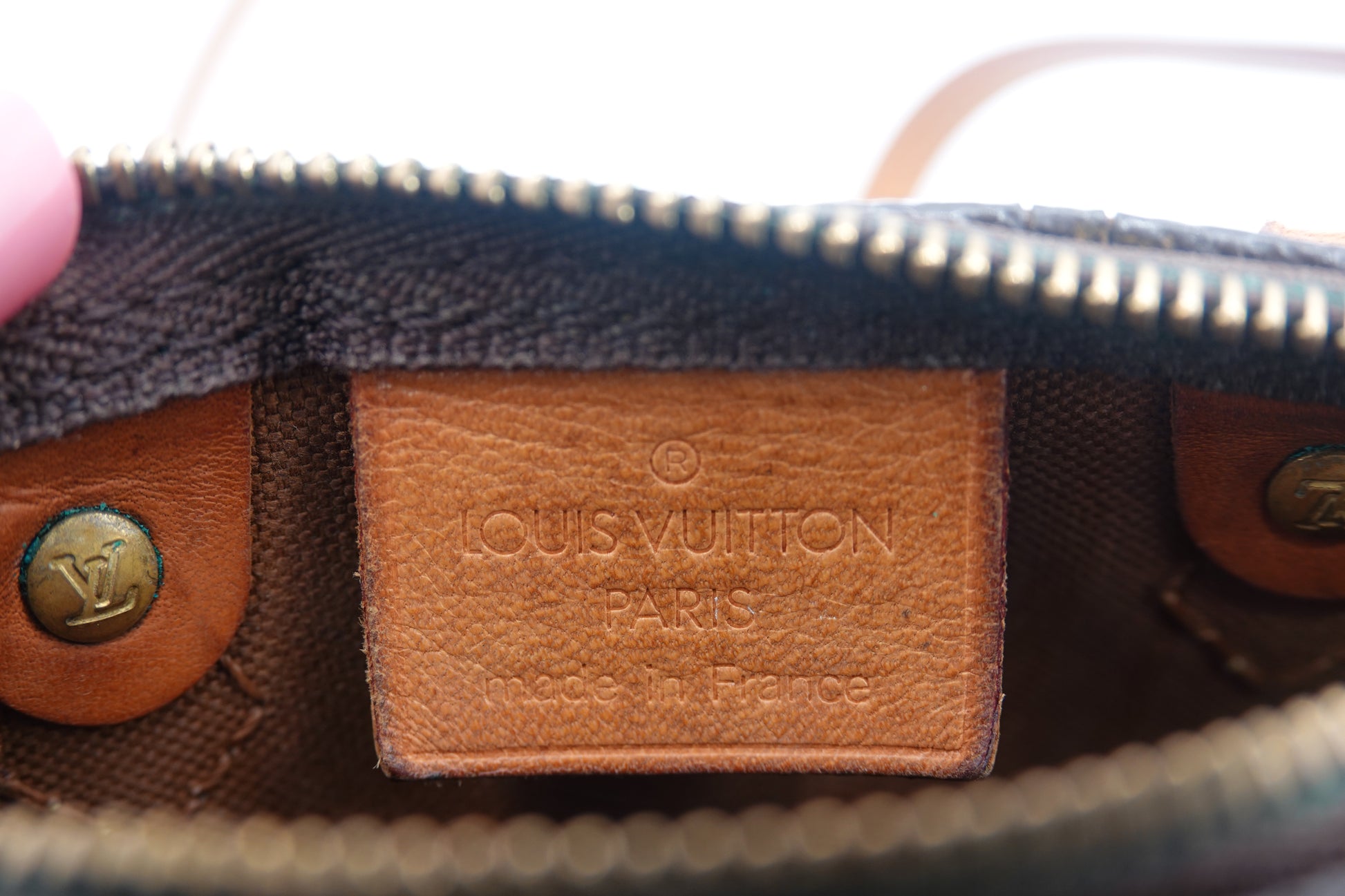 Close-up of a Louis Vuitton logo on a leather patch.