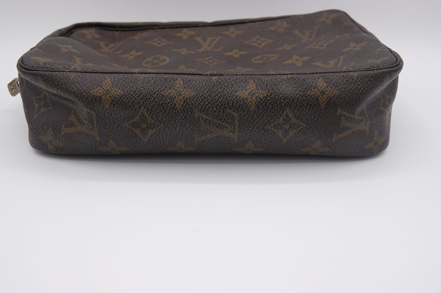 Brown leather bag with brand logo pattern on a white background