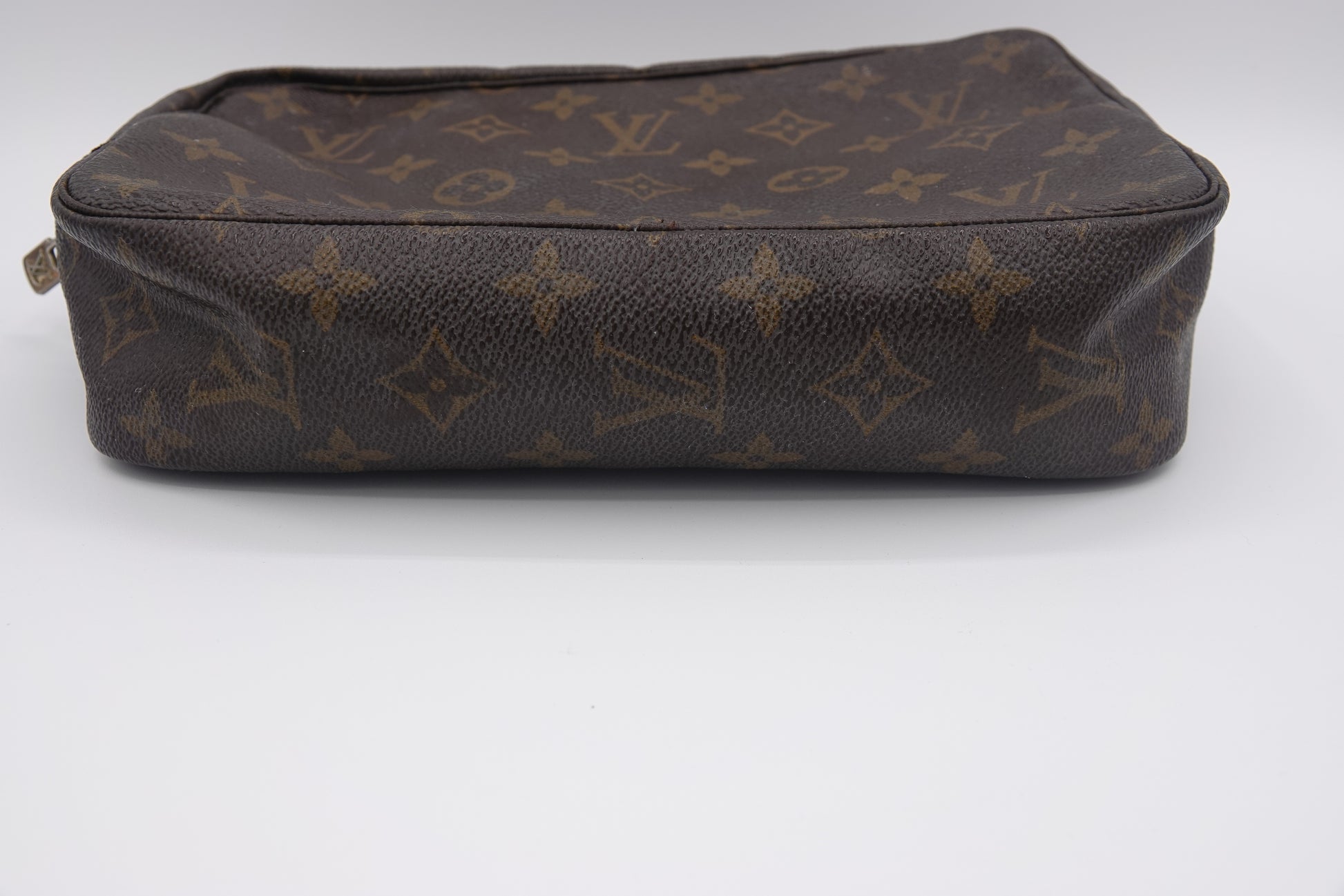 Brown leather bag with brand logo pattern on a white background