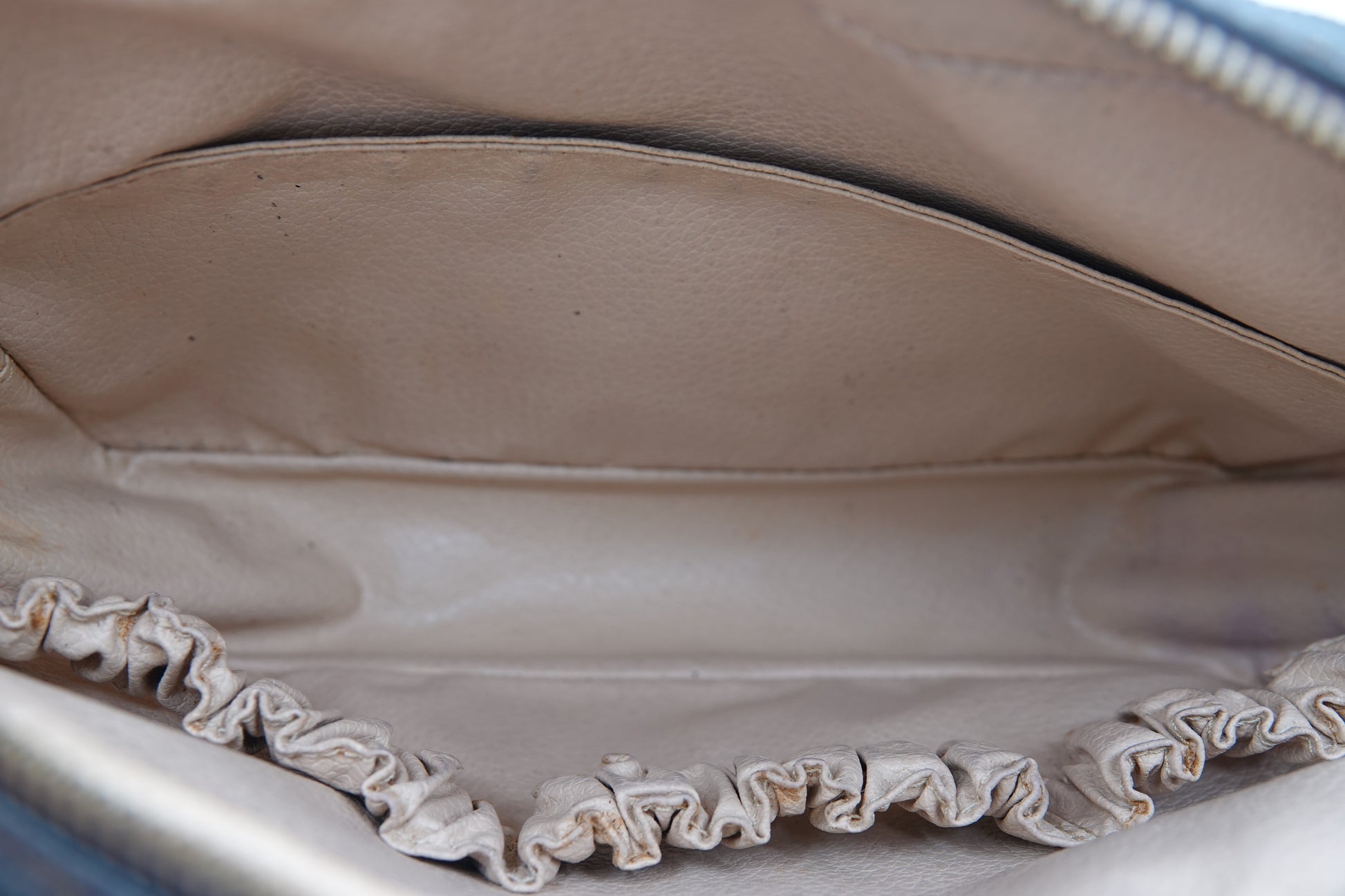 Close-up of a beige leather bag with visible stitching