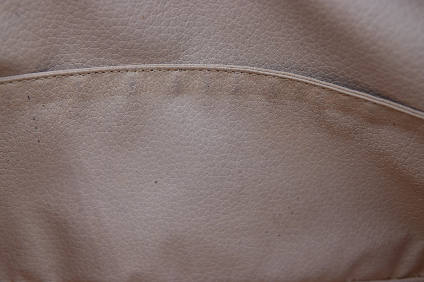 Close-up of beige leather surface with stitching detail