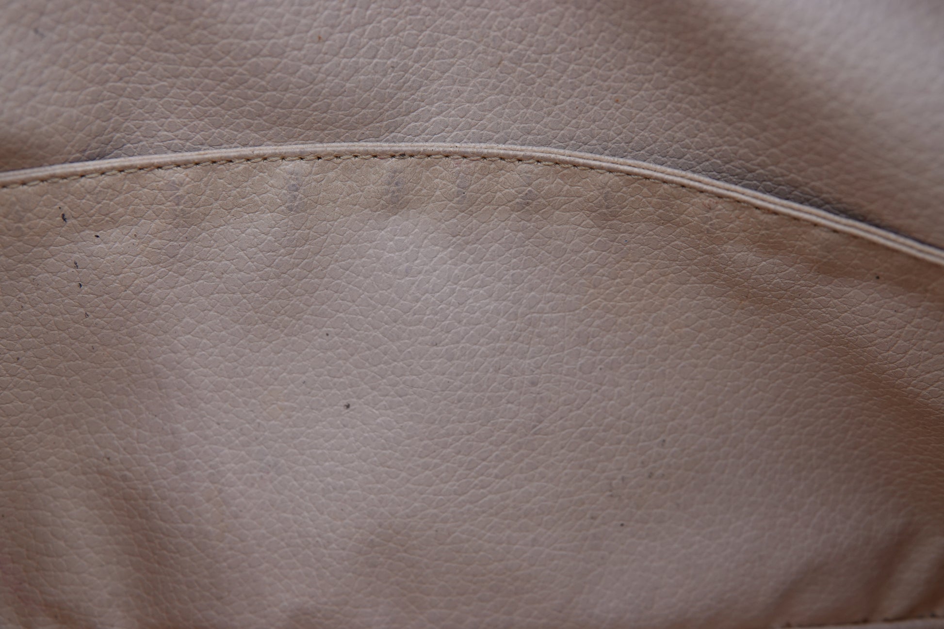 Close-up of beige leather surface with stitching detail