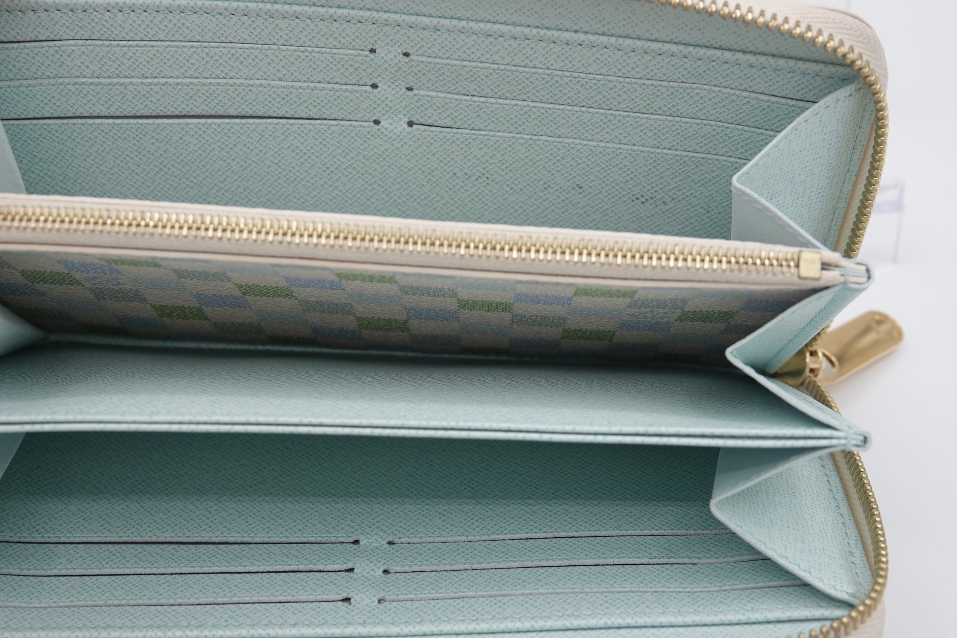 Light blue wallet with gold zipper on a white background