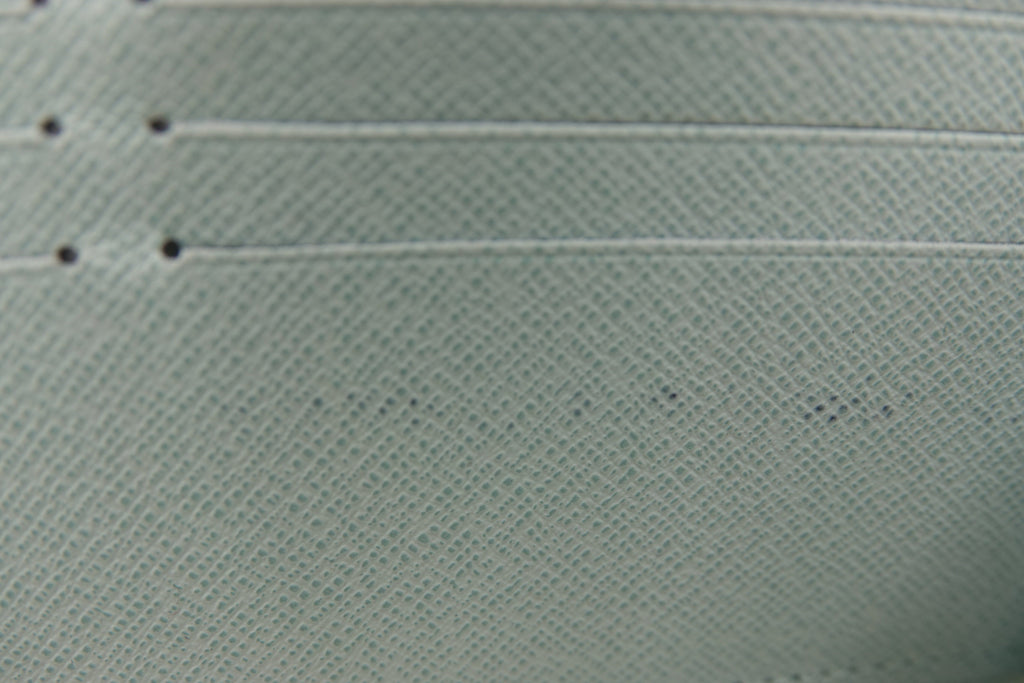 Close-up of a textured light green fabric with visible stitching