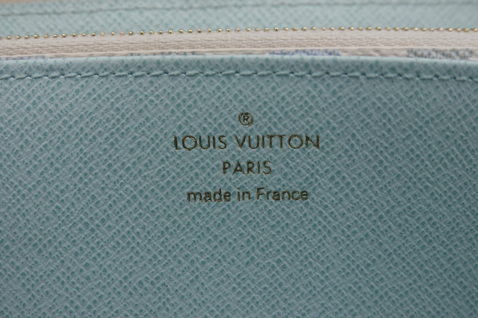 Louis Vuitton logo on a textured blue surface