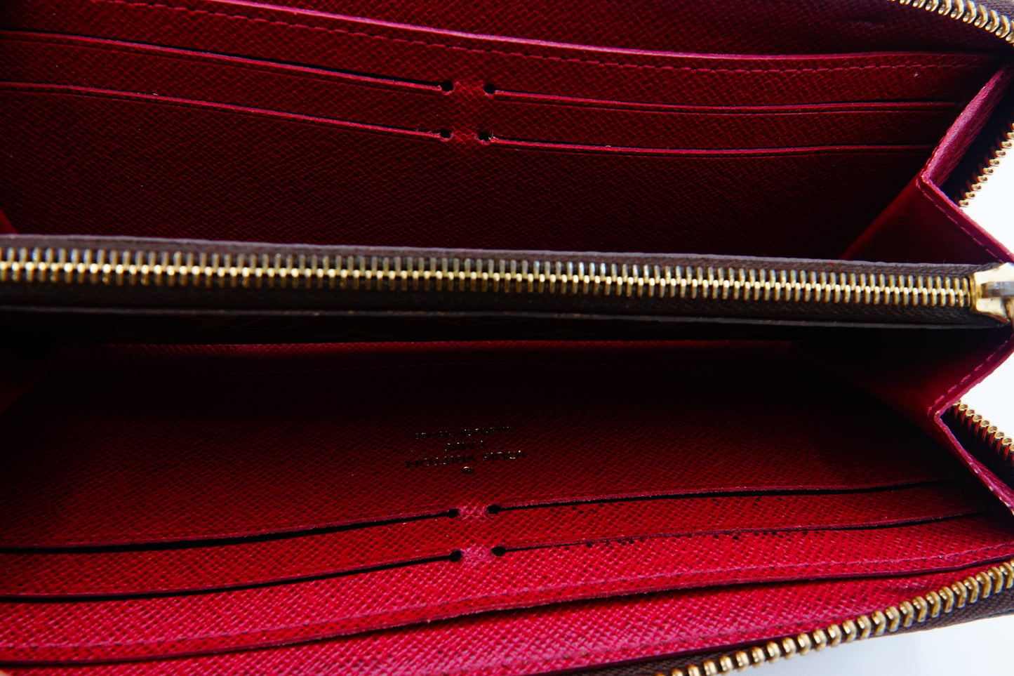 Close-up of a red wallet with a gold zipper