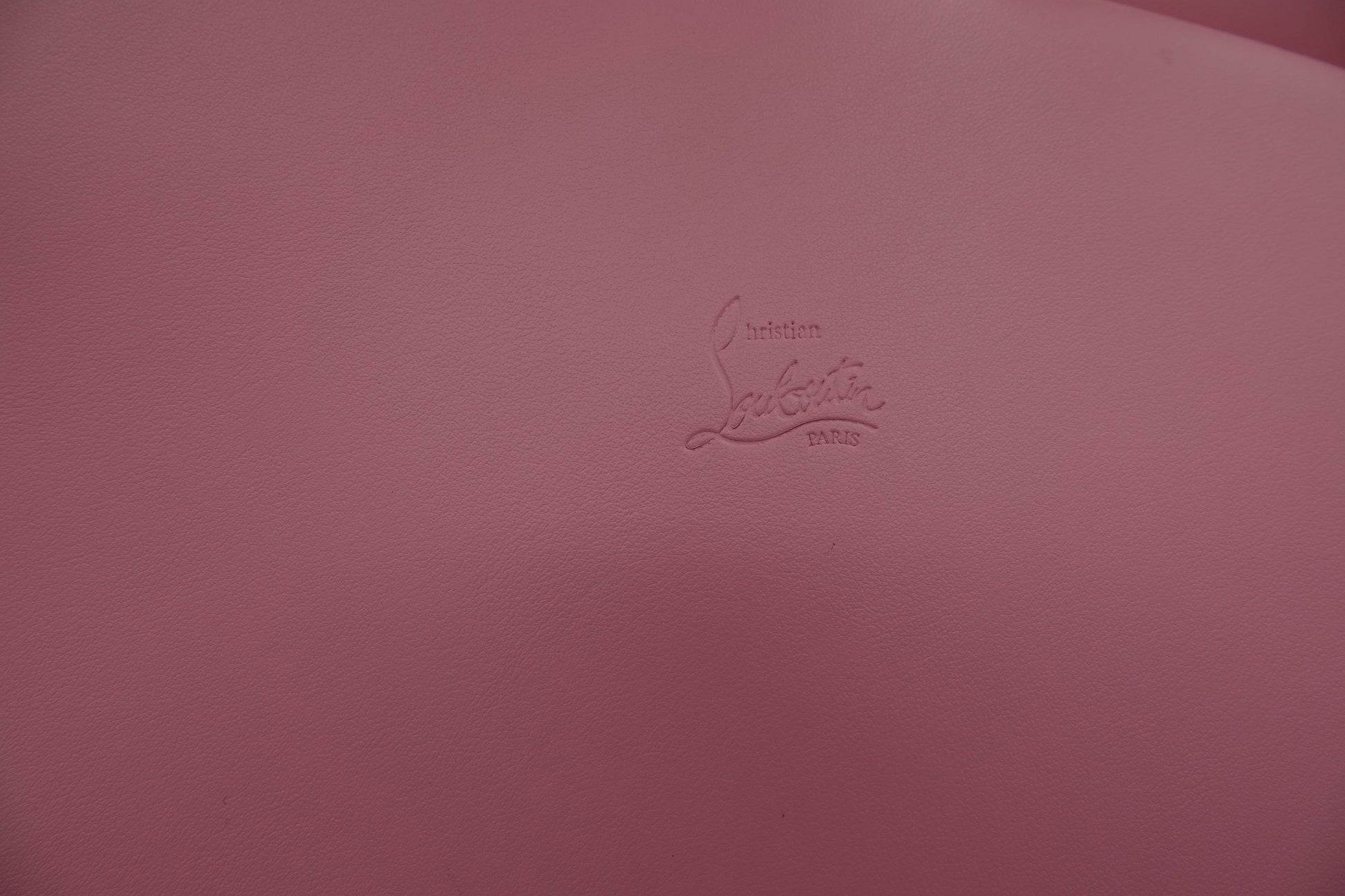 Pink surface with a brand logo embossed on it