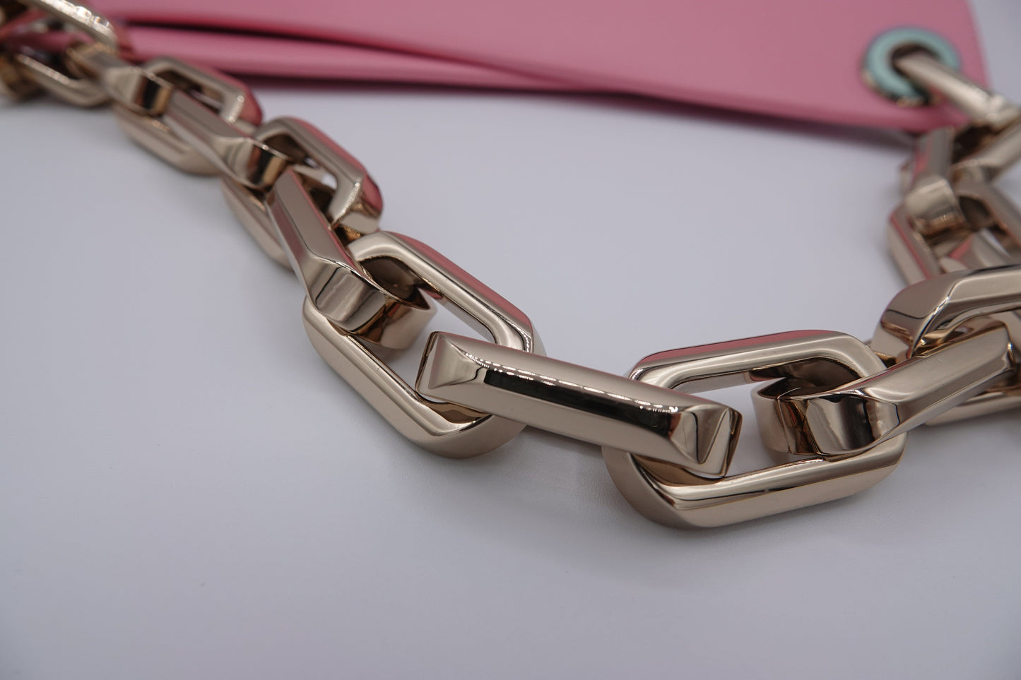 Rose gold chain necklace on a light pink background