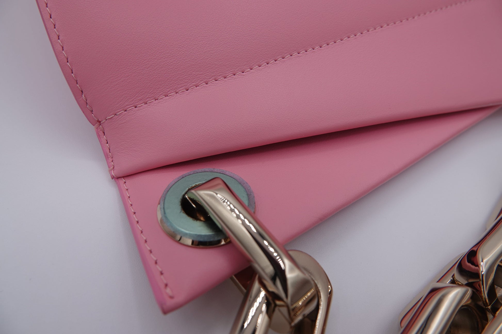 Close-up of a pink handbag with a gold handle on a white background