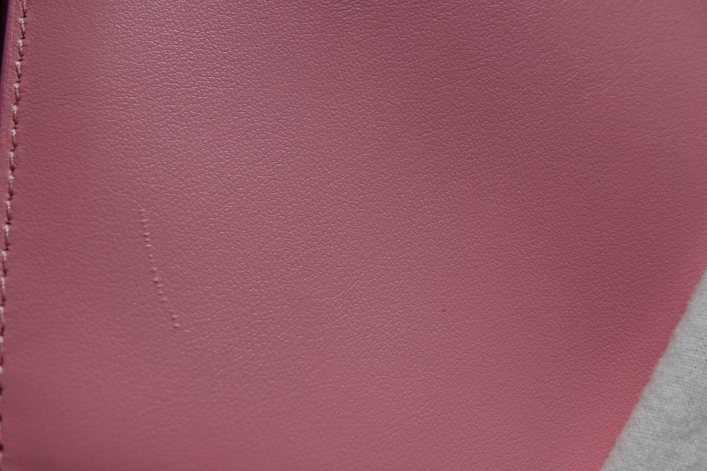 Close-up of a maroon leather surface with visible stitching
