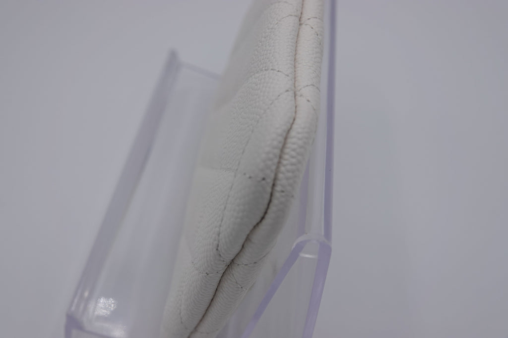 Close-up of a white shoe with a clear plastic stand on a light gray background