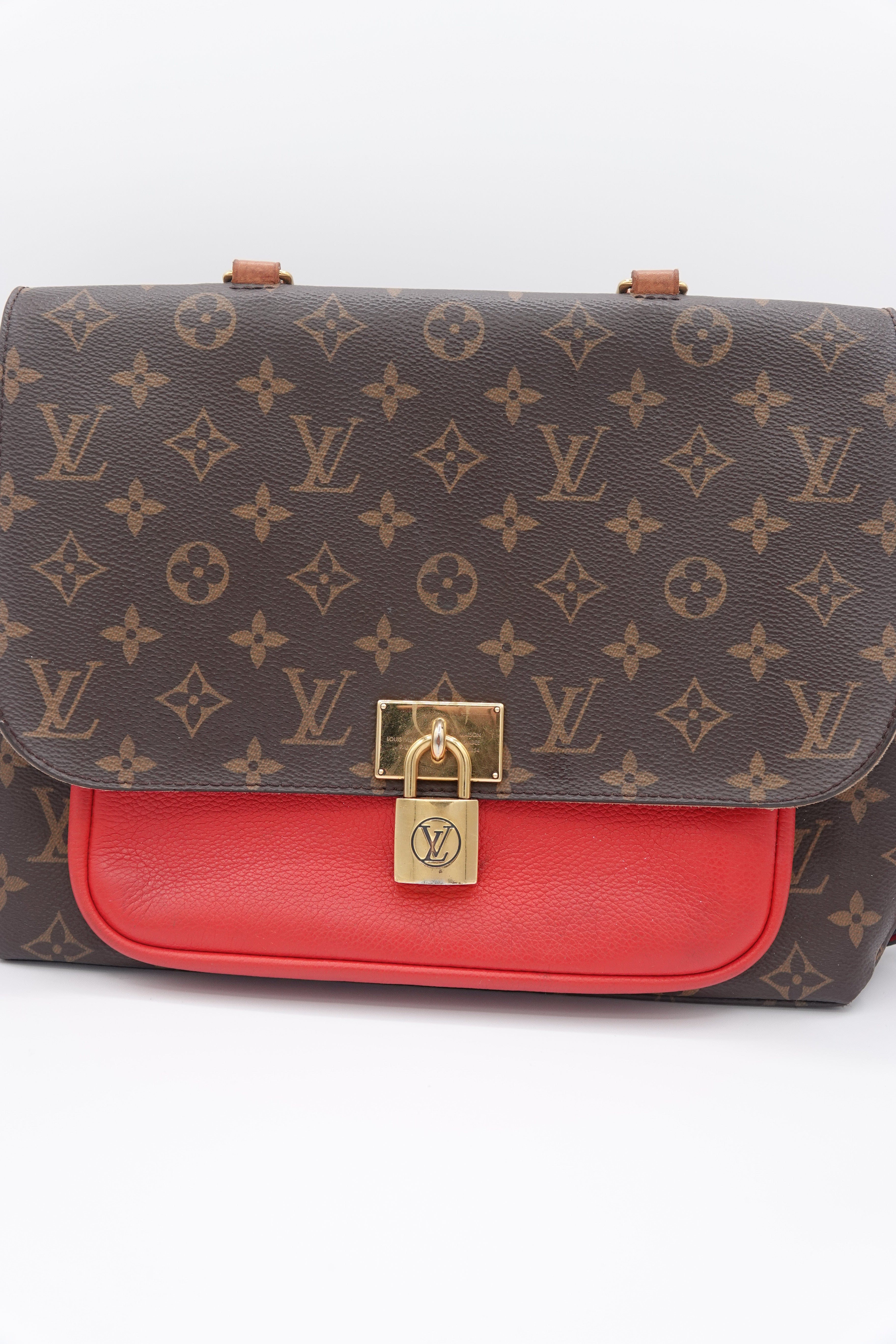 Designer handbag with monogram pattern and red interior on a white background