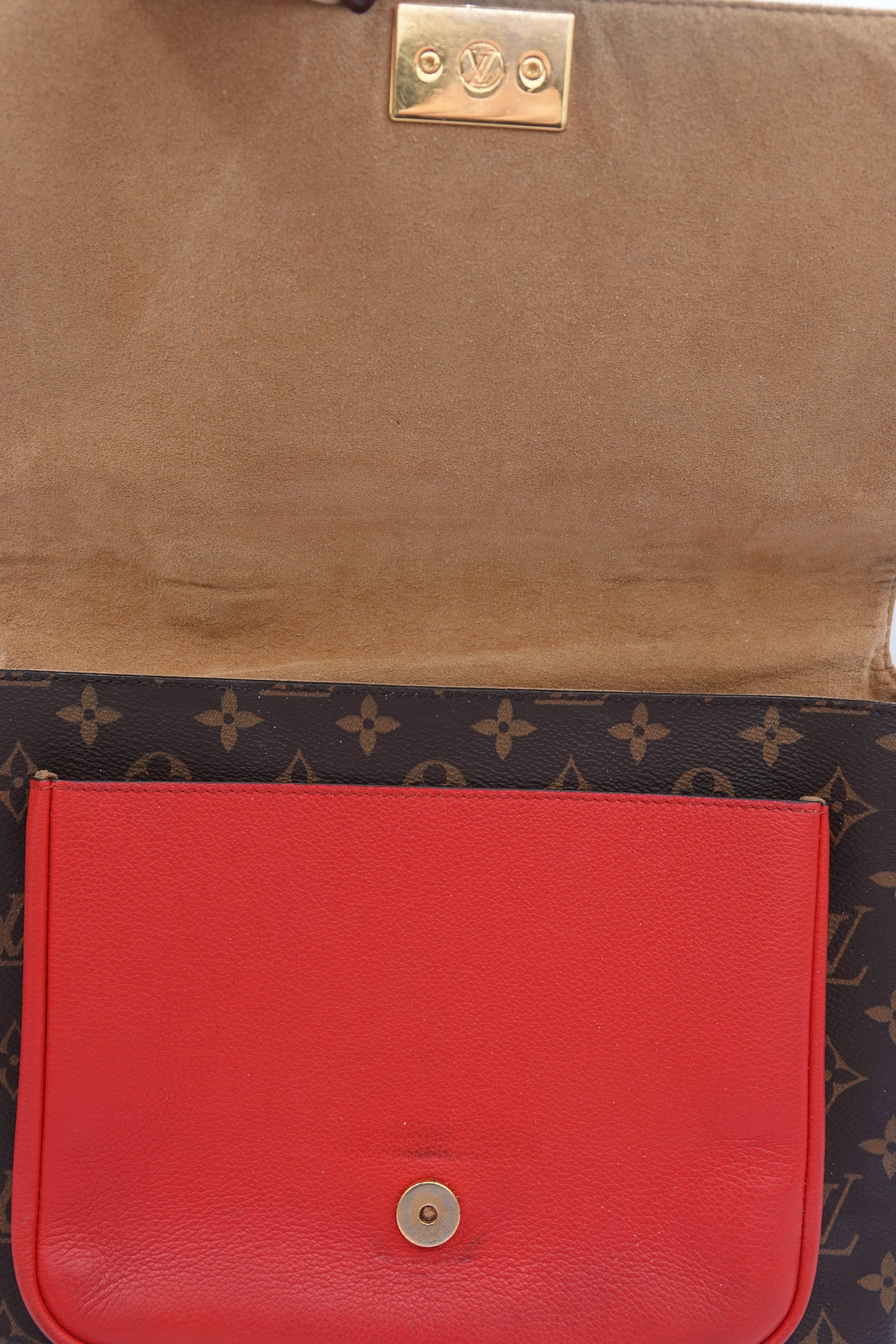 Red leather case and brown leather book on a patterned surface
