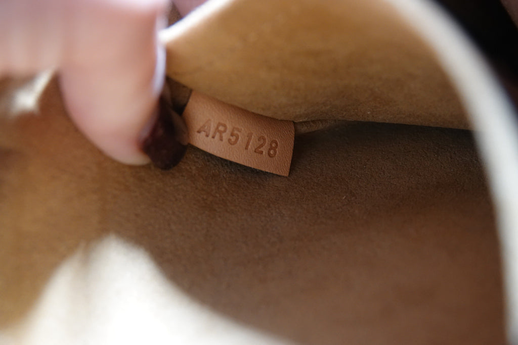 Close-up of a brown leather product with a visible tag number AR5128.