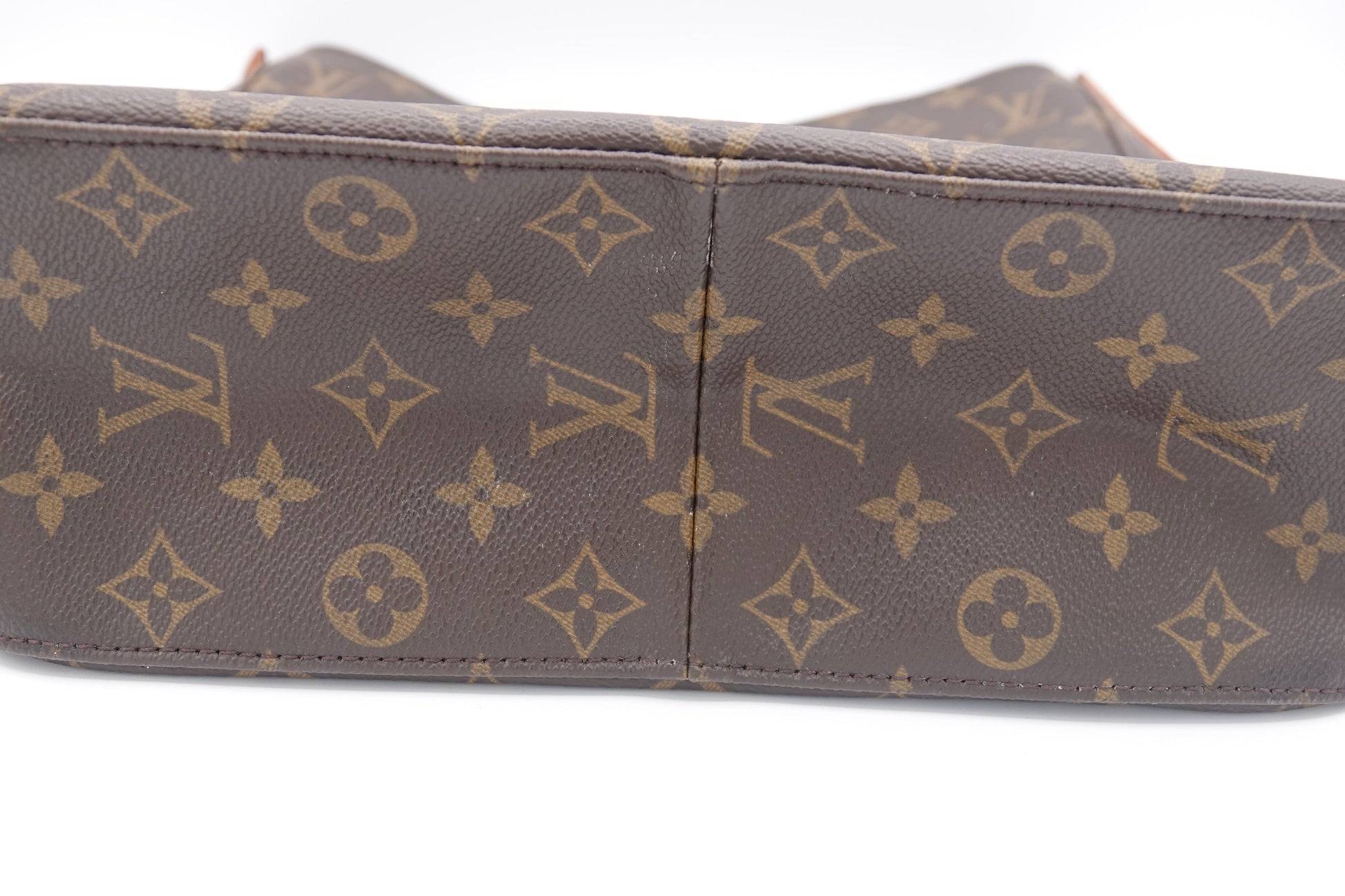 Close-up of a brown leather bag with a patterned design on a white background