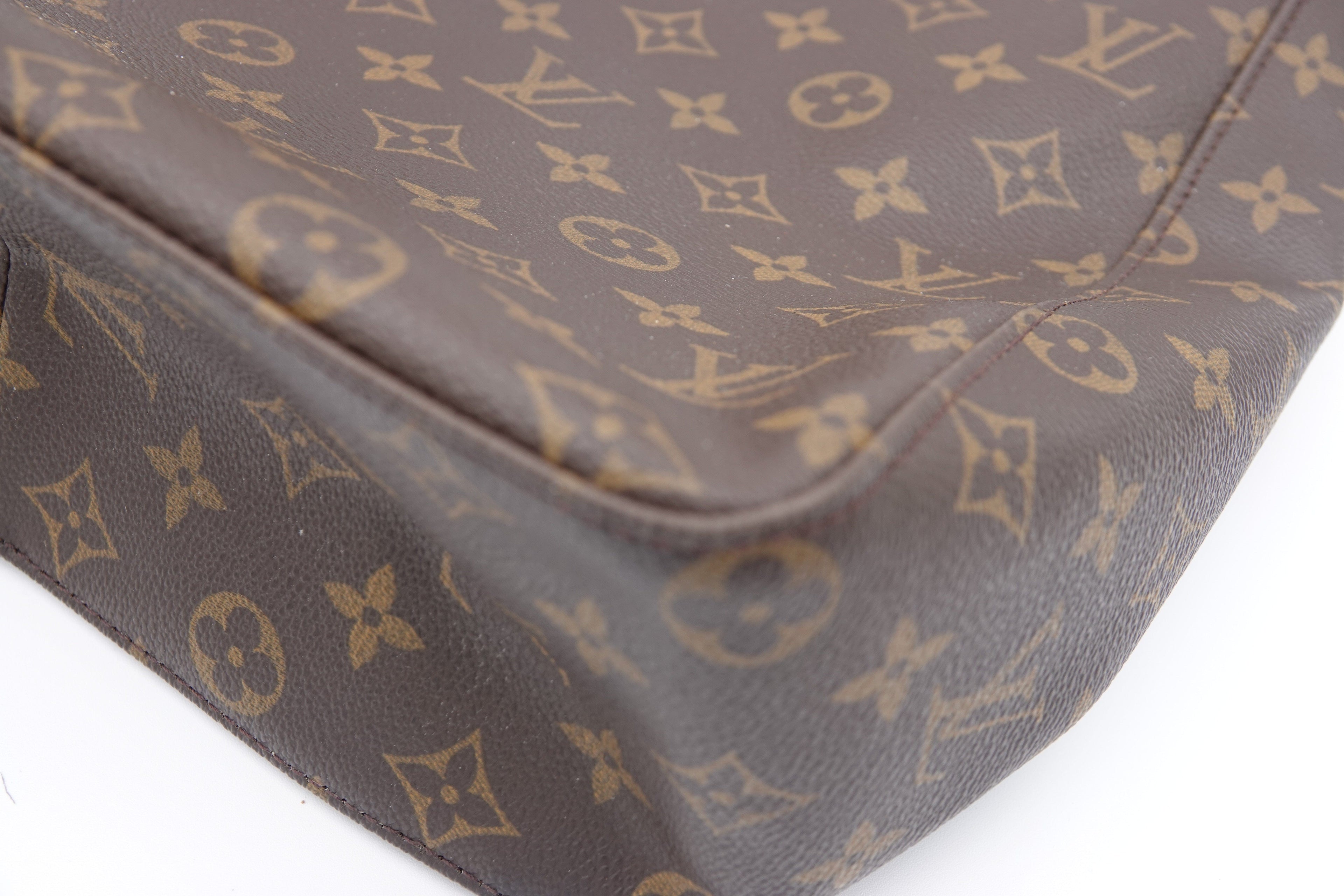 Brown suitcase with gold monogram pattern on a white background