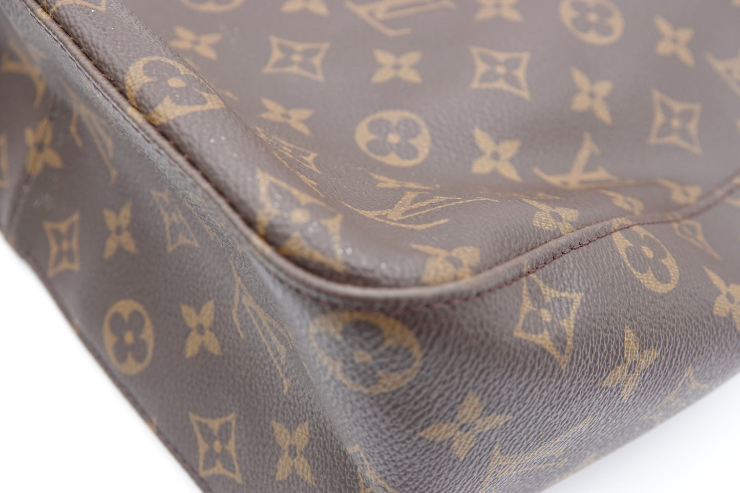 Close-up of a brown leather bag with gold monogram pattern