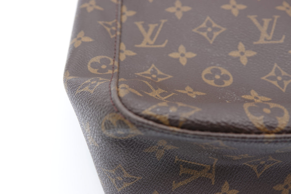 Close-up of a Louis Vuitton monogram handbag corner on a white background
