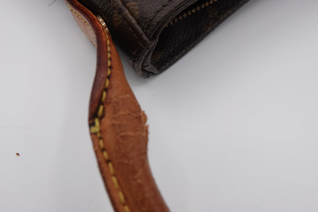 Close-up of a brown leather strap with stitching on a white background