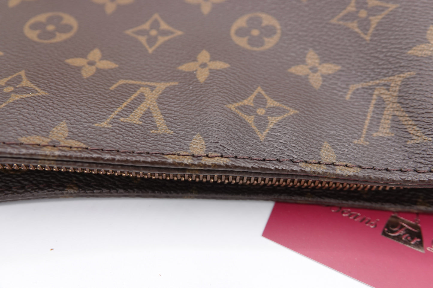 Brown leather wallet with gold monogram pattern on a white background