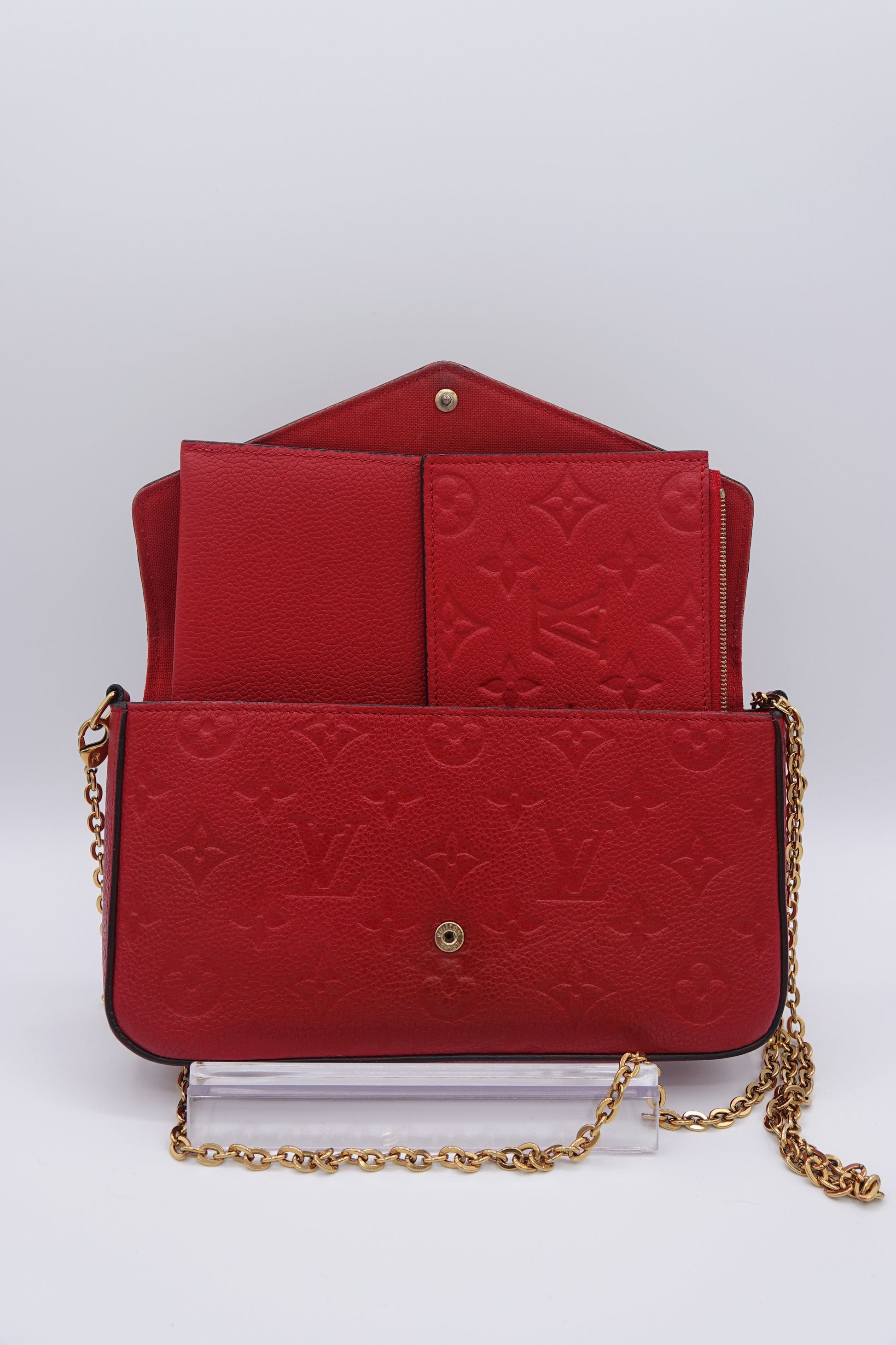 Red embossed handbag with gold chain on a white background