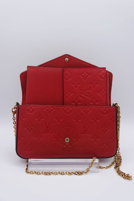 Red embossed handbag with gold chain on a white background