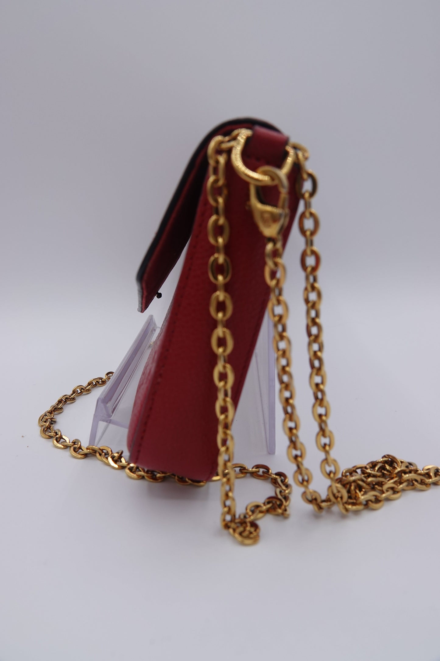 Red handbag with gold chain on a white background