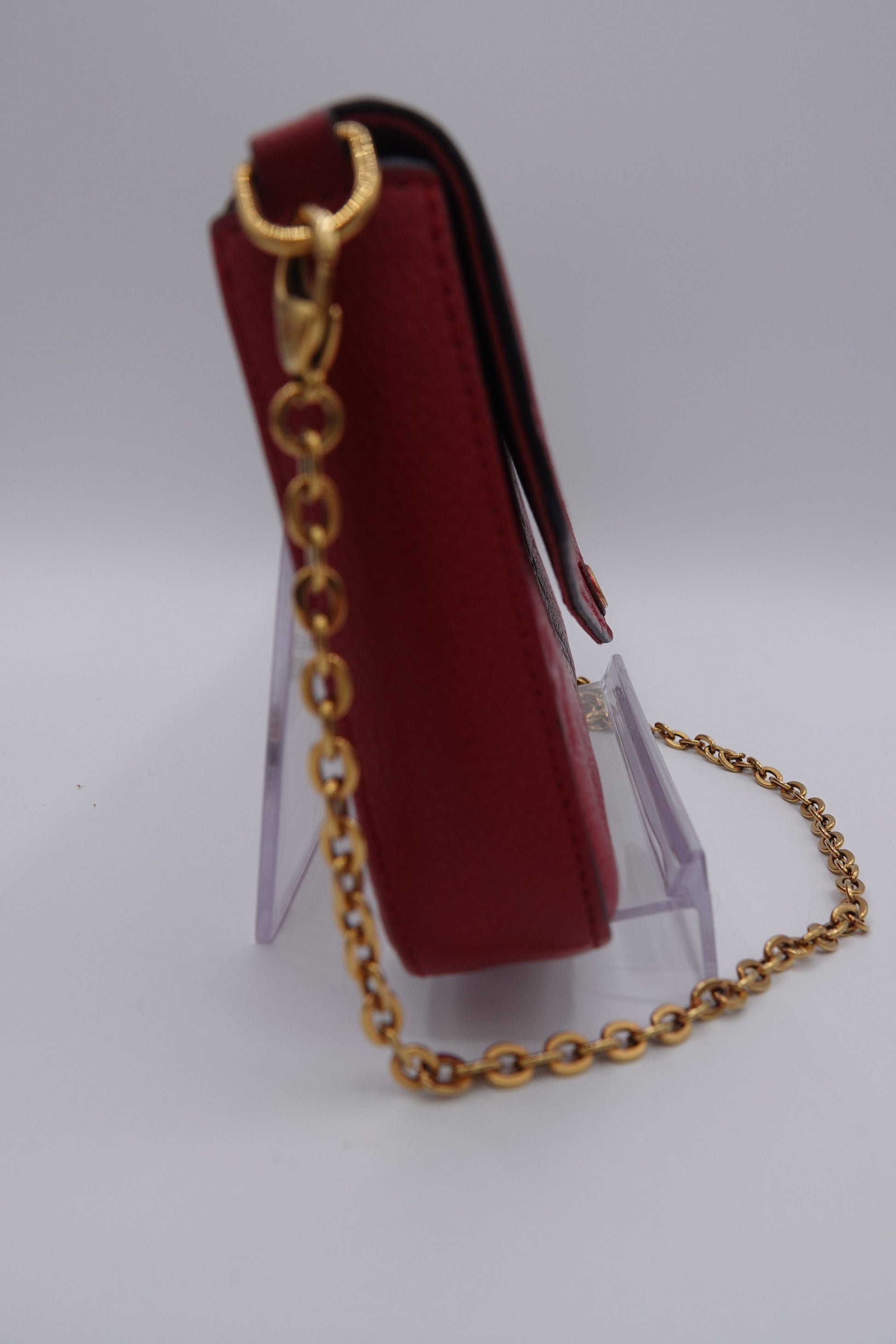 Red wallet with gold chain on a white background