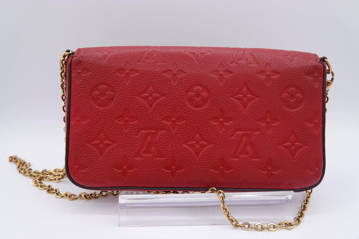 Red handbag with gold chain on a white background