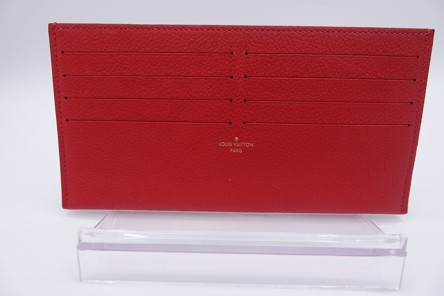 Red wallet with Louis Vuitton logo on a white background