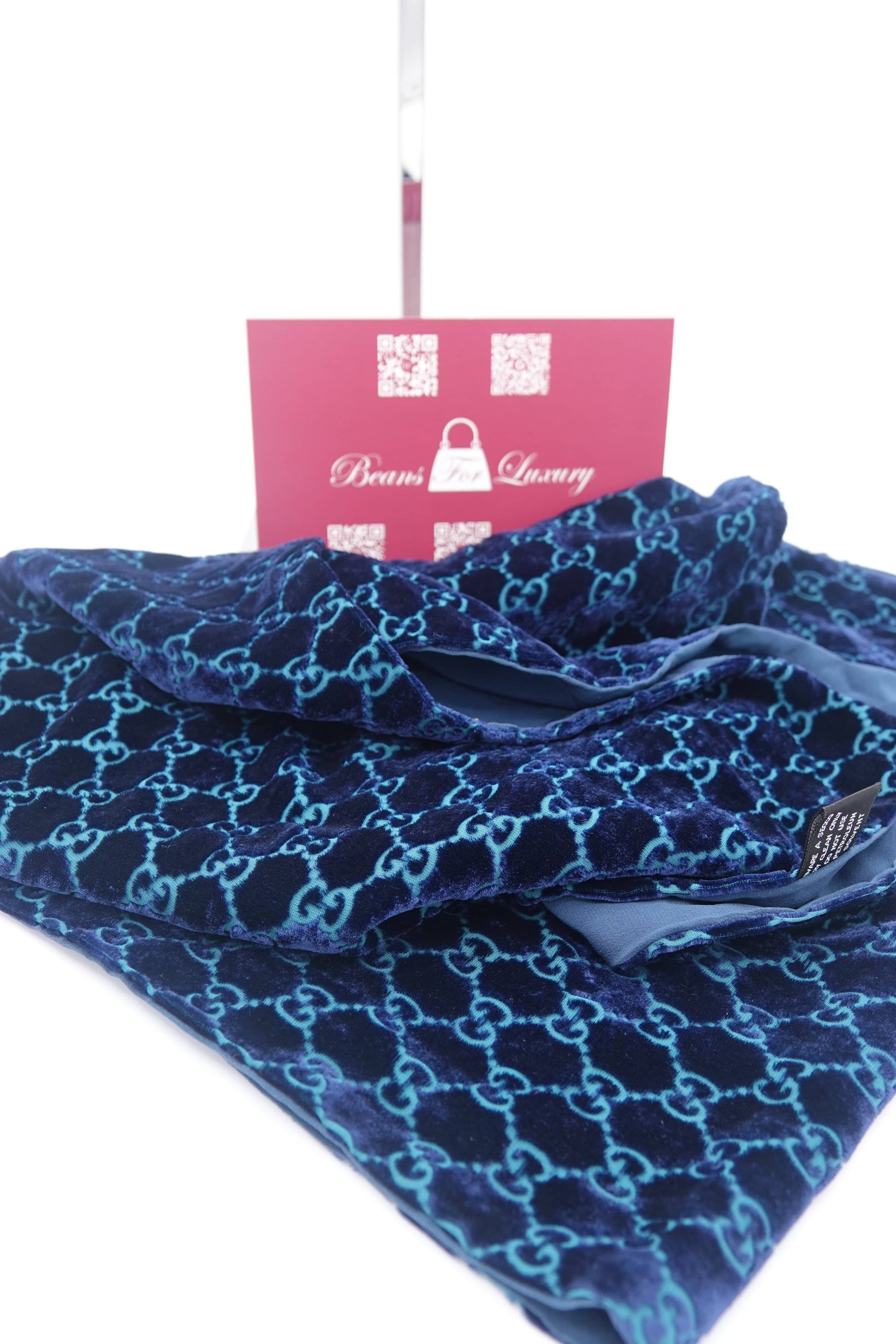 Blue patterned towel with a pink tag on a white background