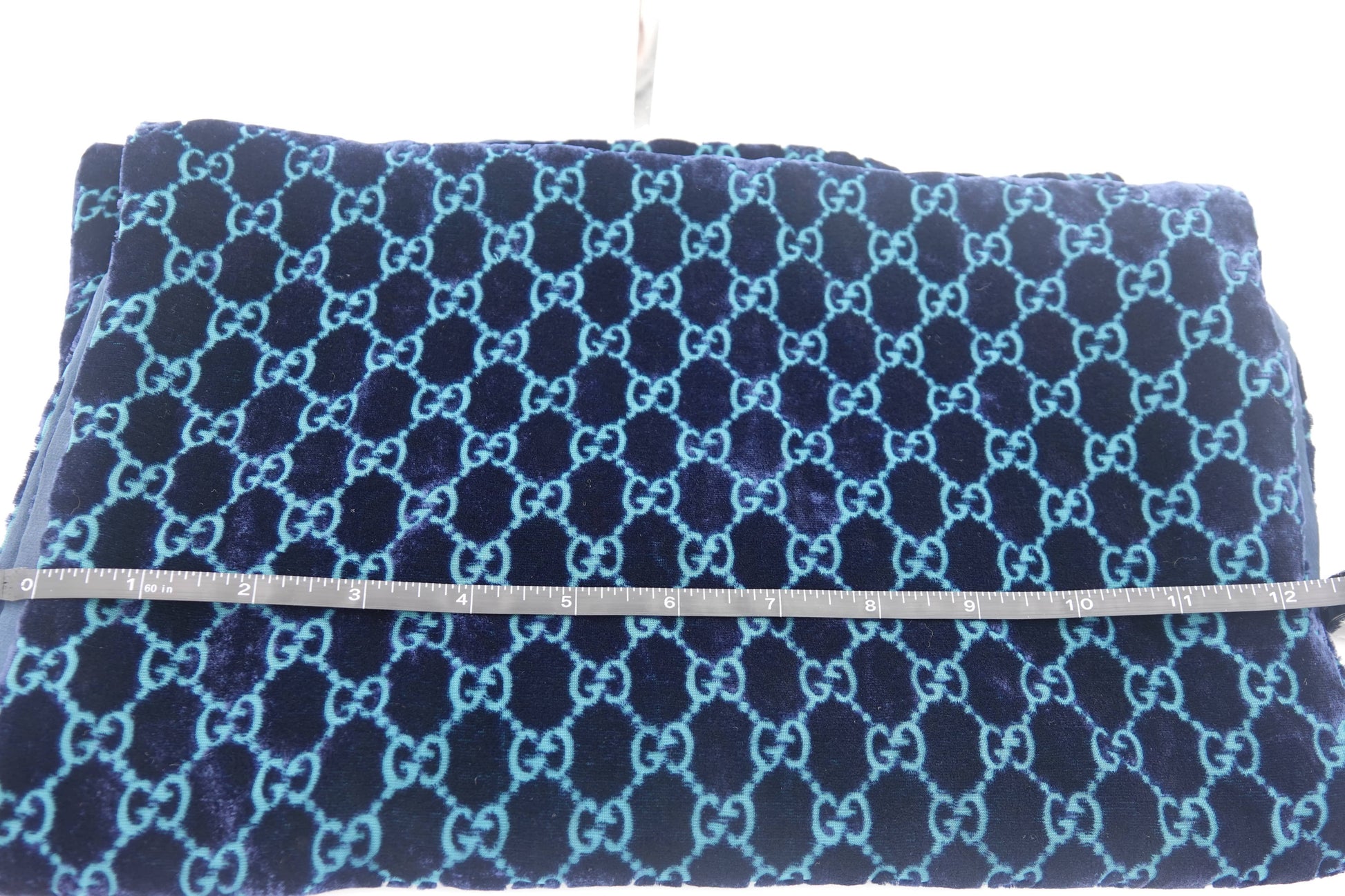 Blue patterned fabric with a visible brand logo on a white background