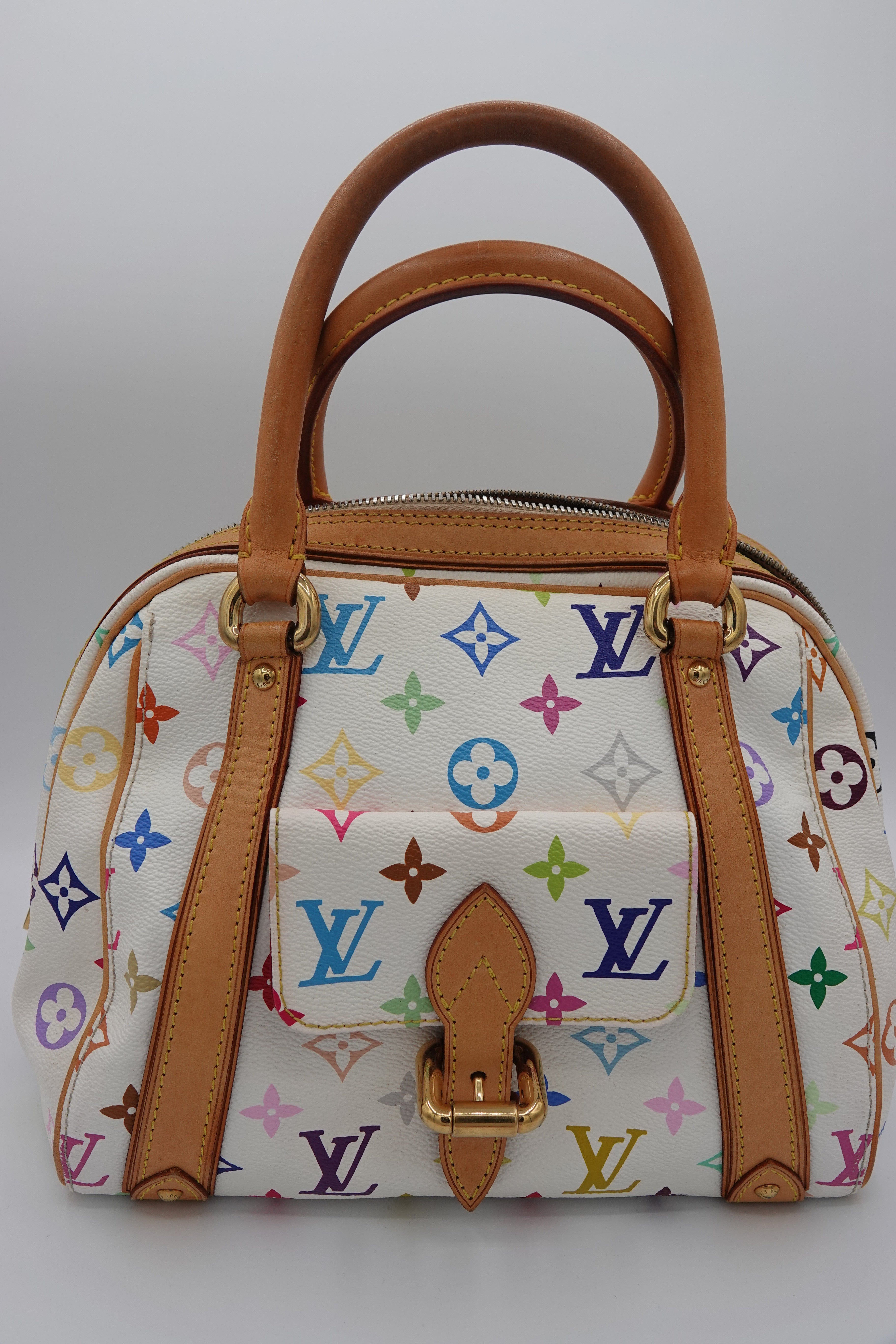 Designer handbag with multicolor logo pattern and brown leather handles on a light gray background