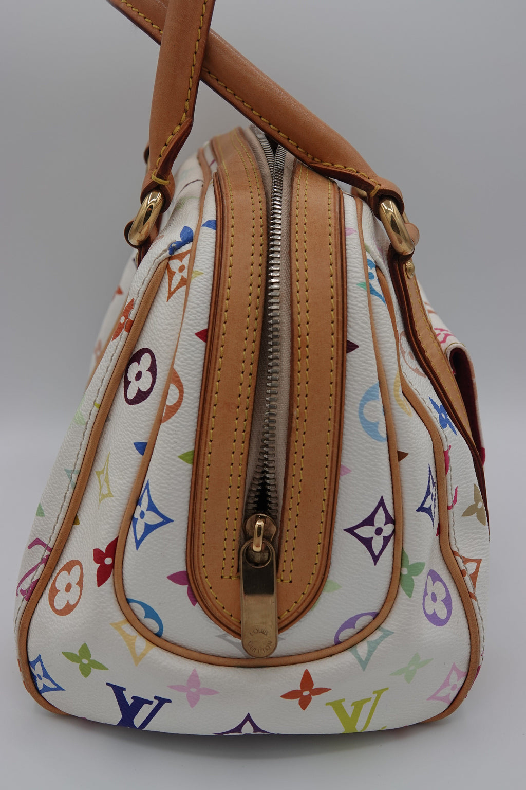 Designer handbag with multicolor logo pattern on a white background