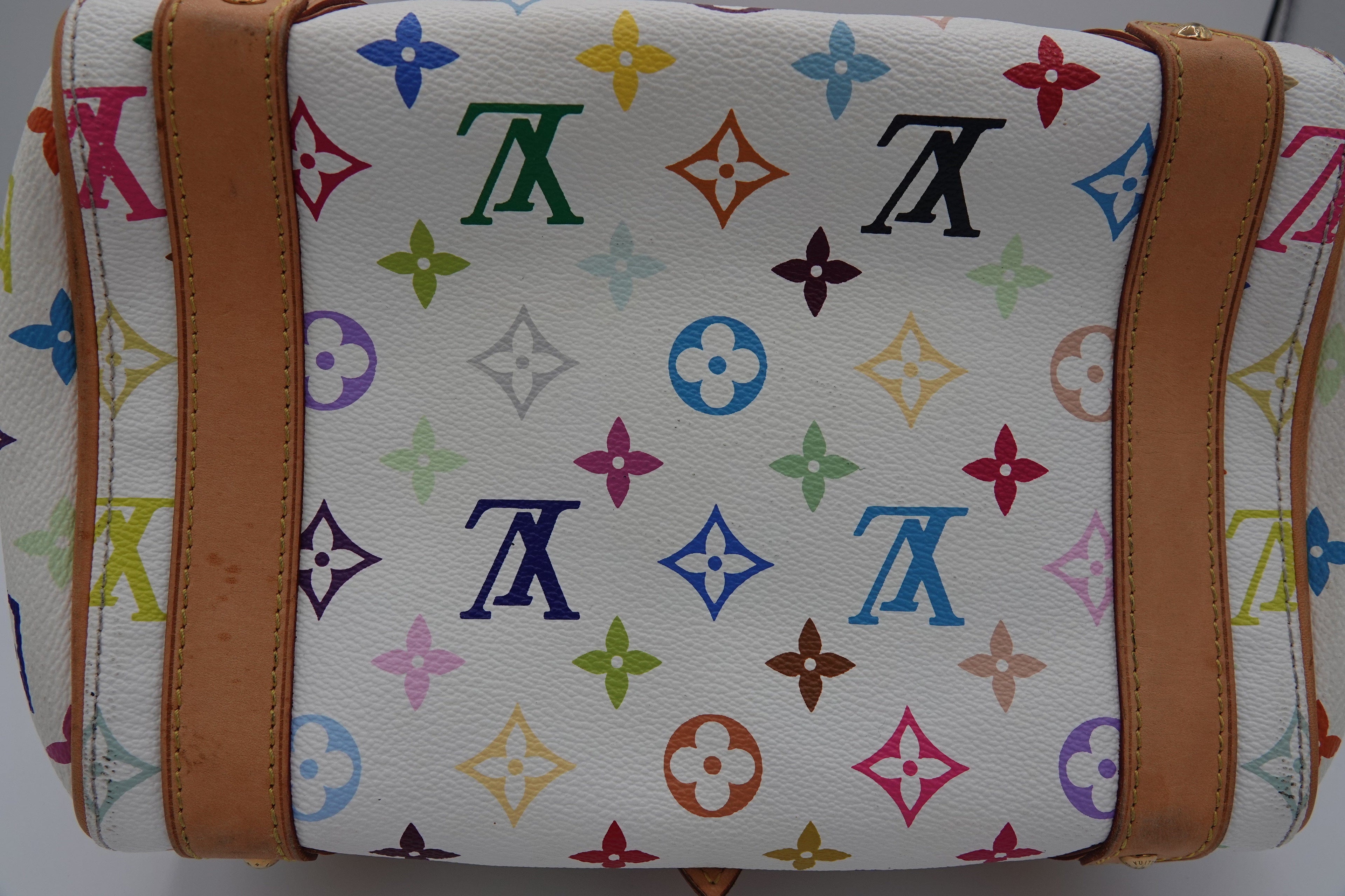 White bag with colorful monogram pattern and brown leather straps