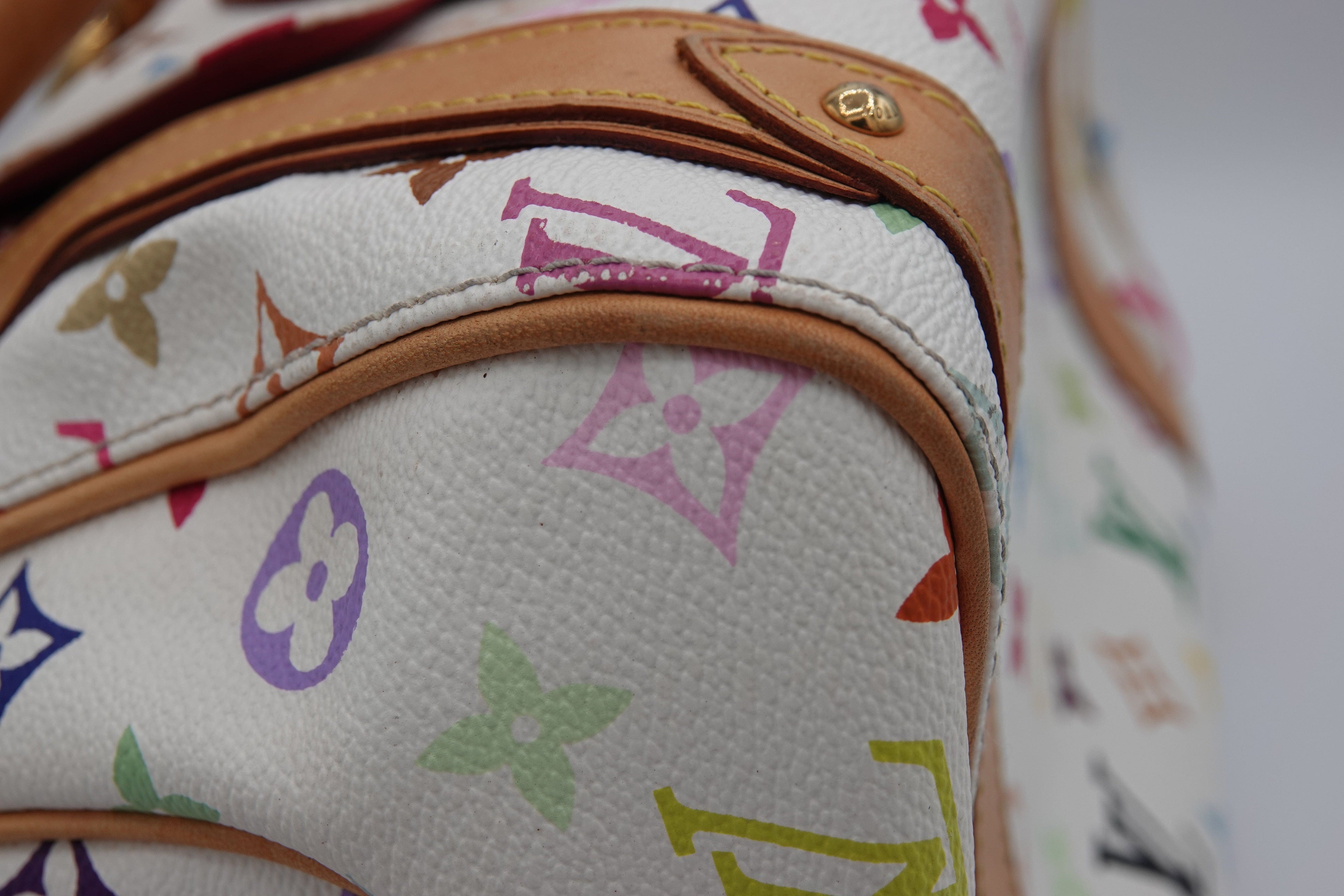 Close-up of a Louis Vuitton handbag with multicolor monogram pattern.