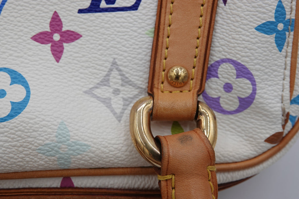 Close-up of a handbag with floral pattern and brown leather strap.
