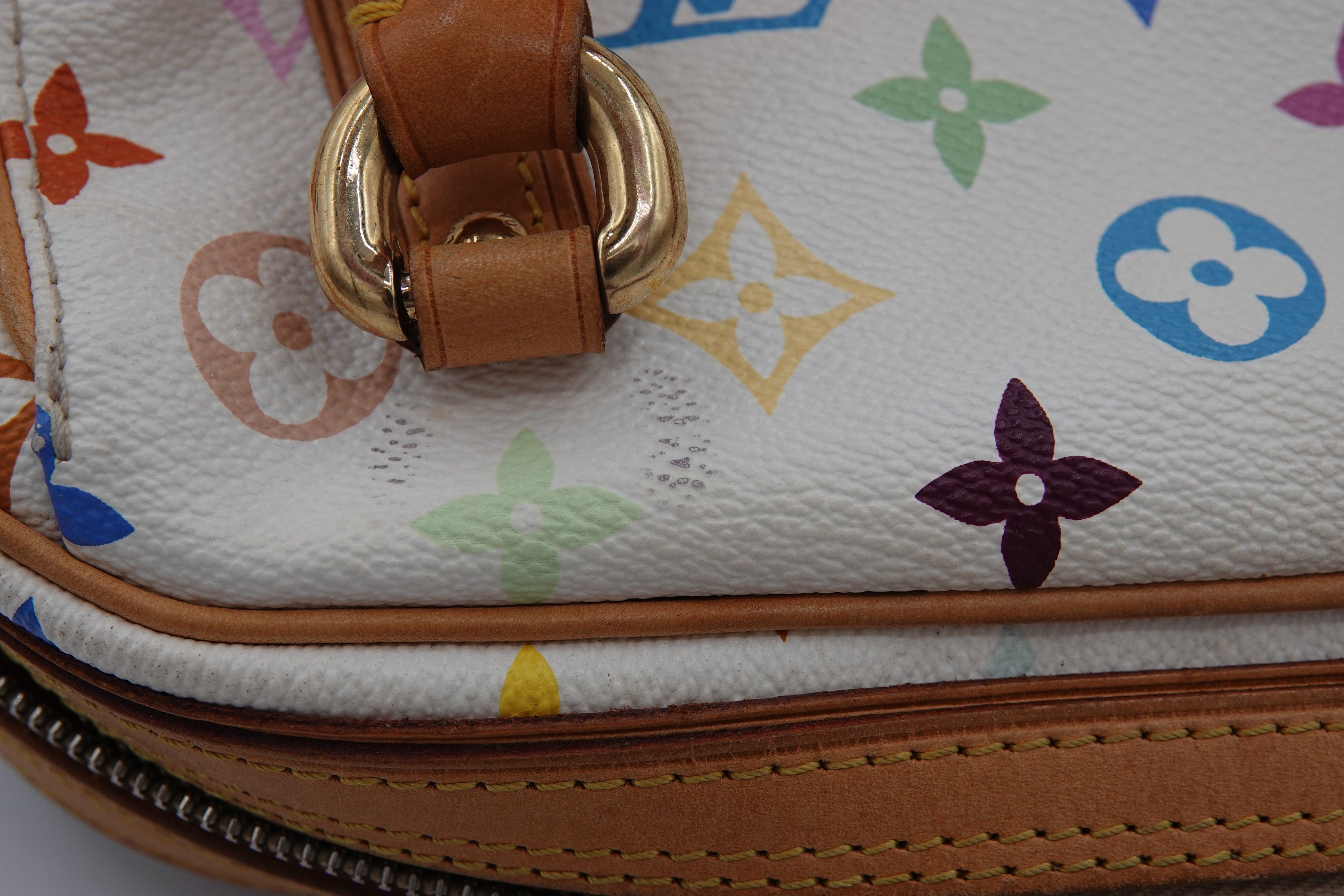 Close-up of a multicolored patterned handbag with a gold buckle.