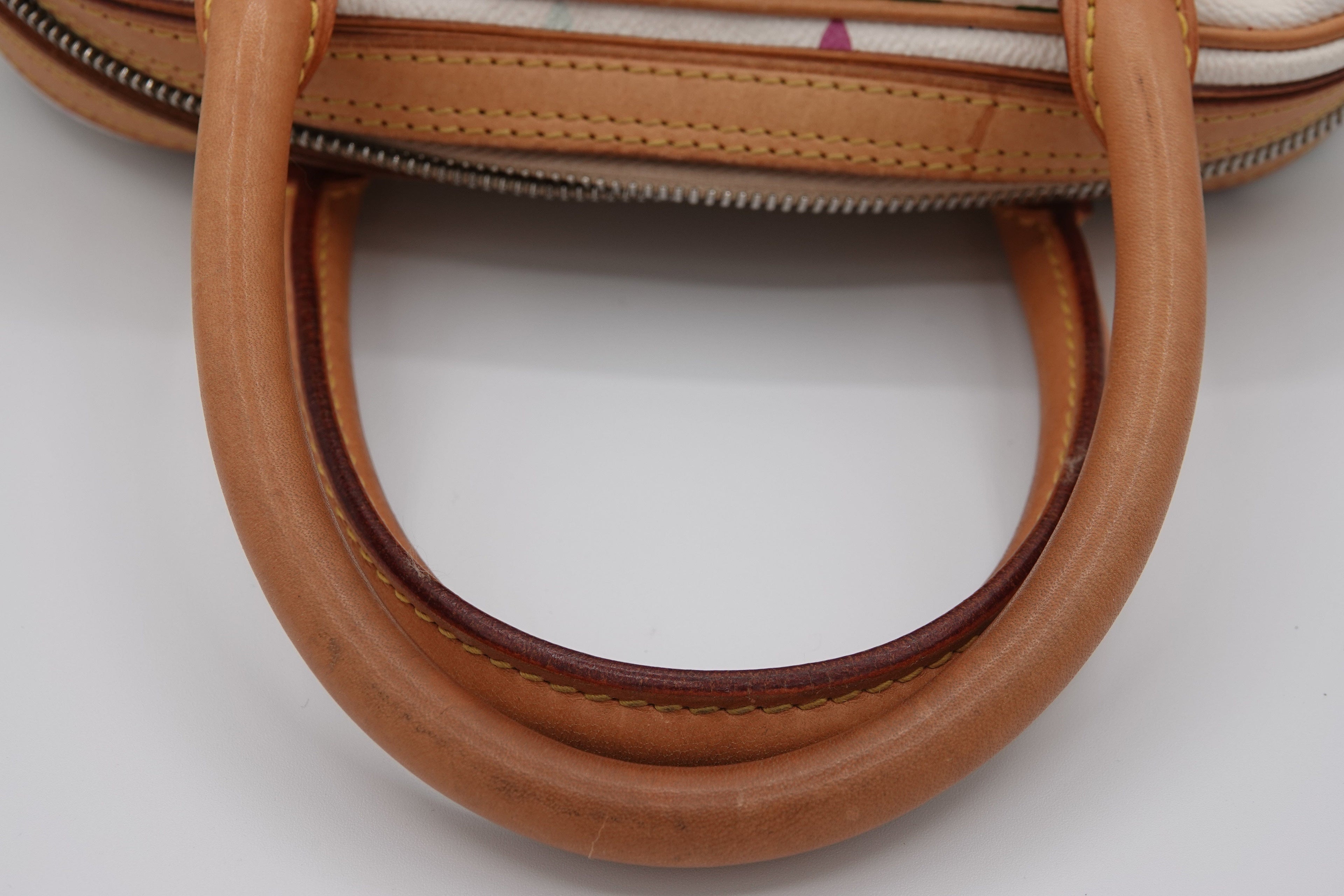 Close-up of a brown leather handbag handle on a white background