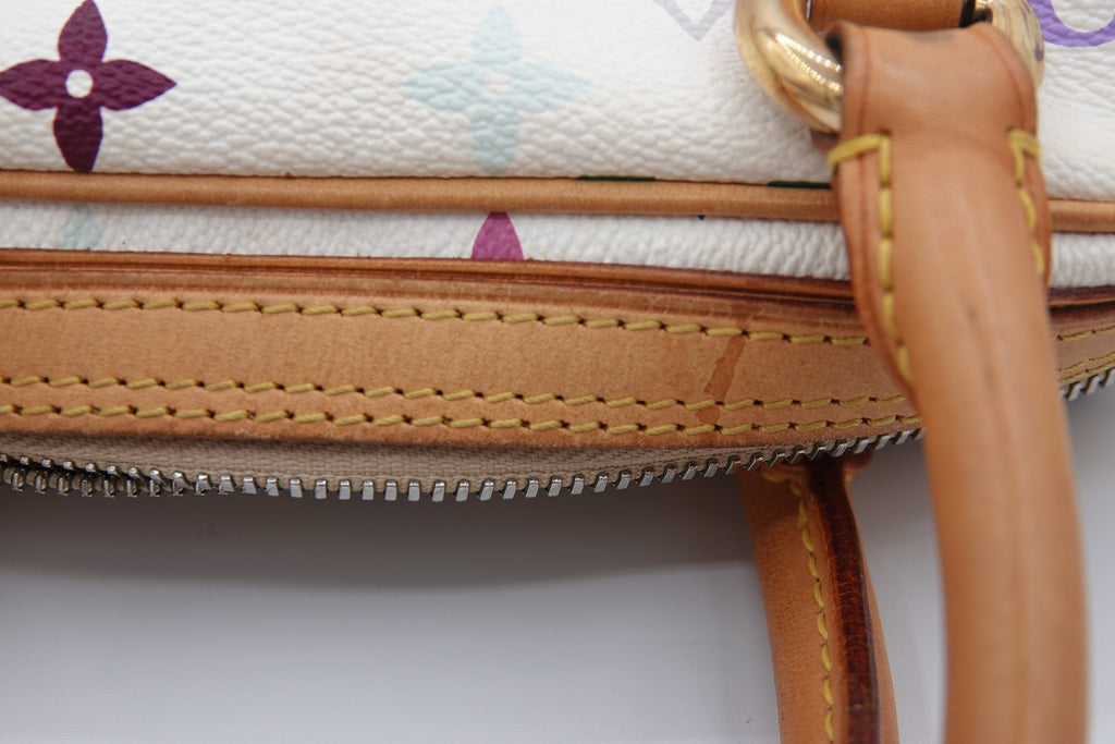 Close-up of a handbag with floral pattern and brown handle on a white background