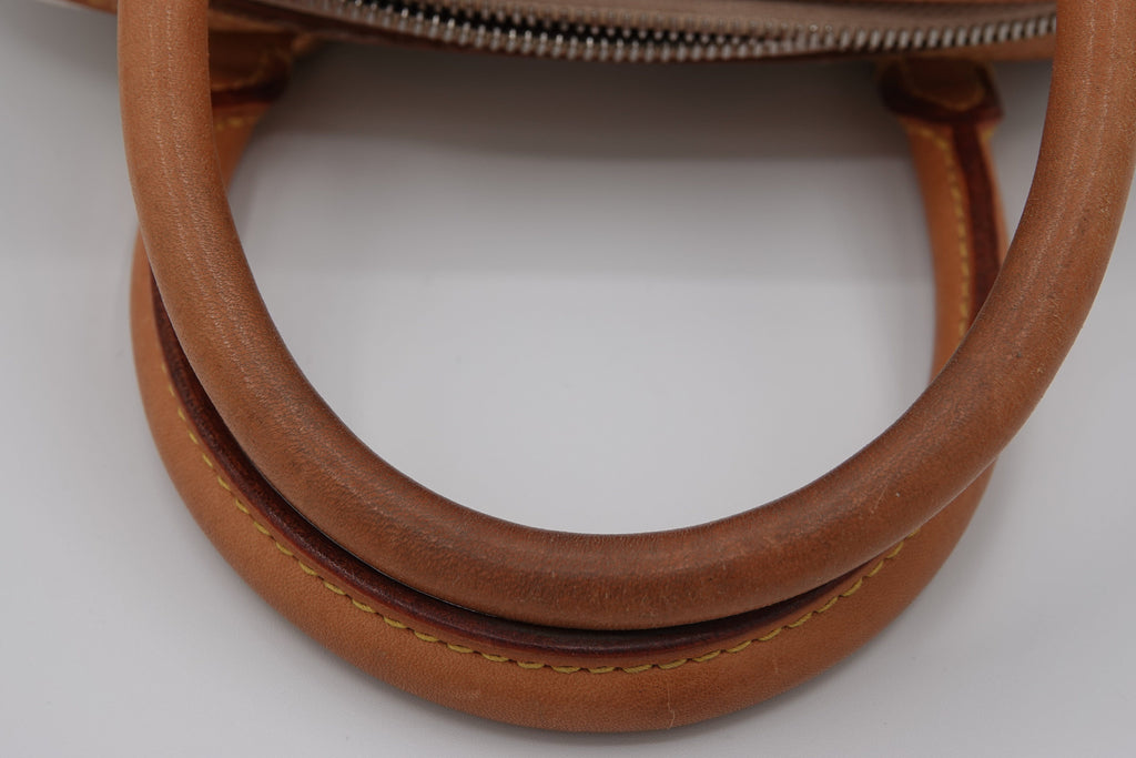 Close-up of a brown leather handbag handle on a white background