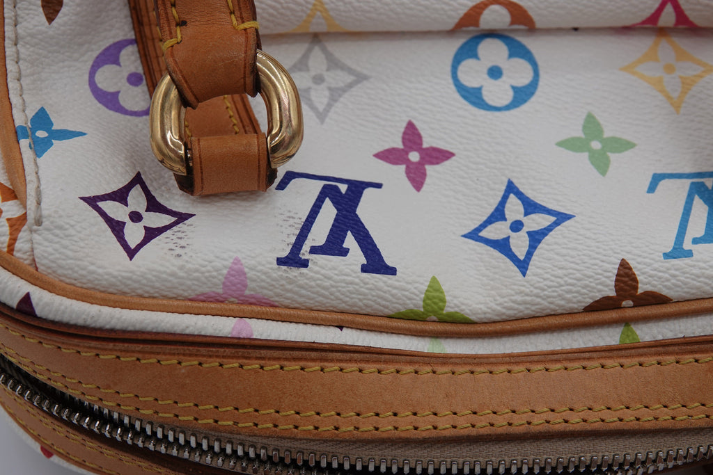 Close-up of a multicolored patterned bag with brown leather strap and zipper.