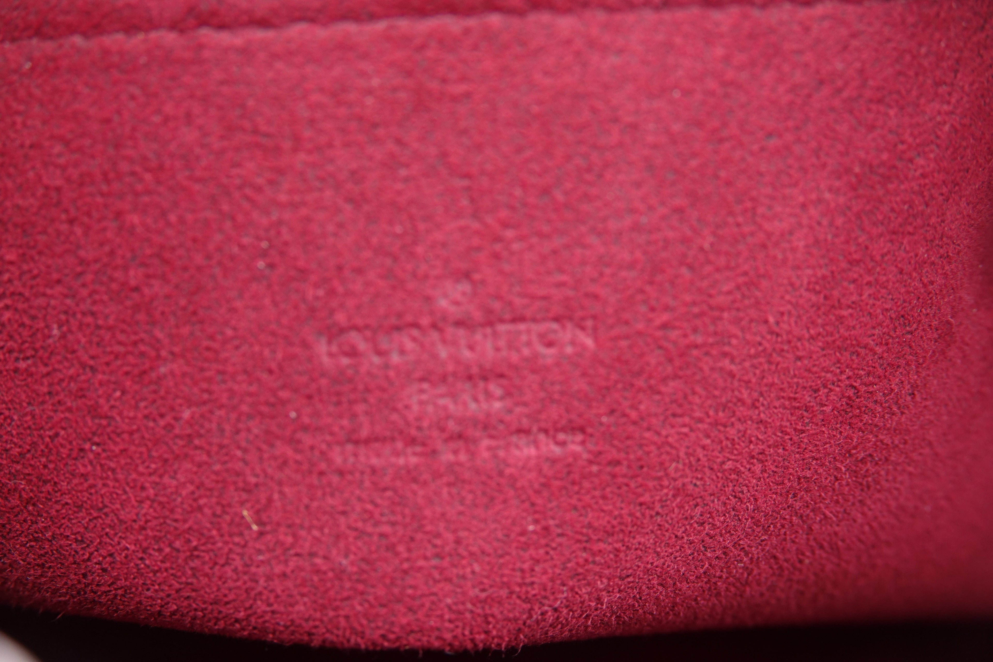 Close-up of a textured red surface with a brand logo.