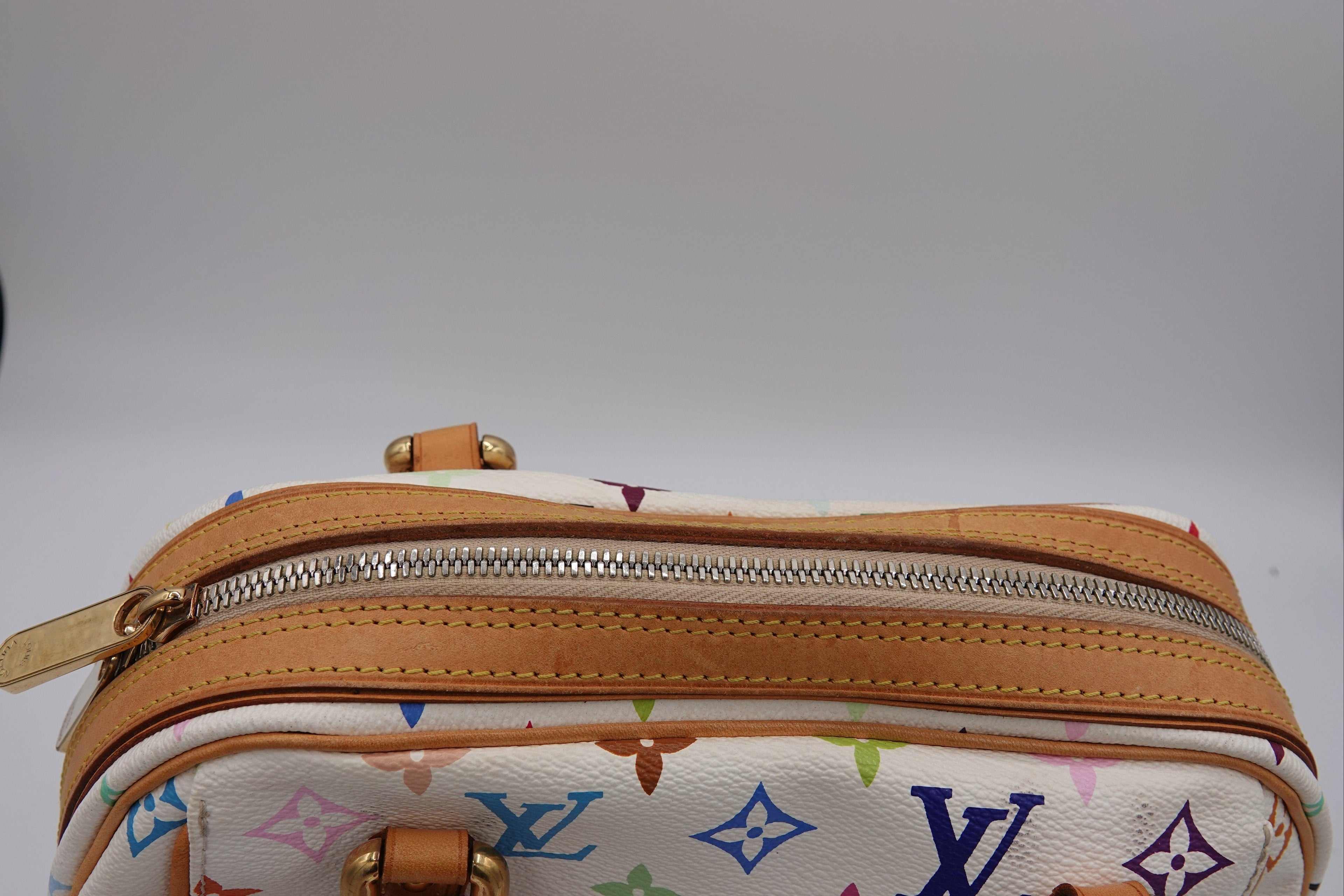 Designer handbag with multicolor monogram pattern on a white background