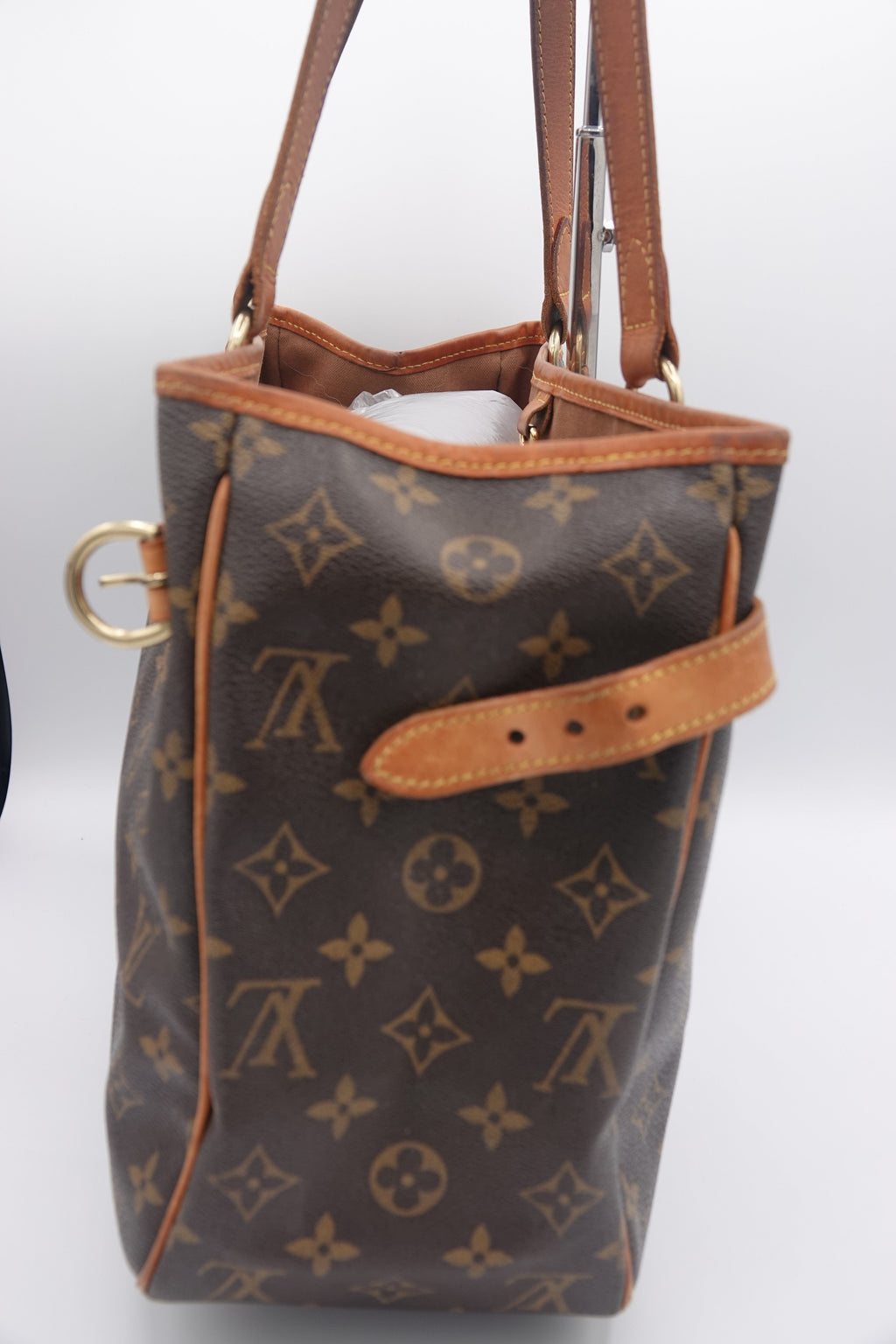 Brown leather handbag with gold hardware on a white background