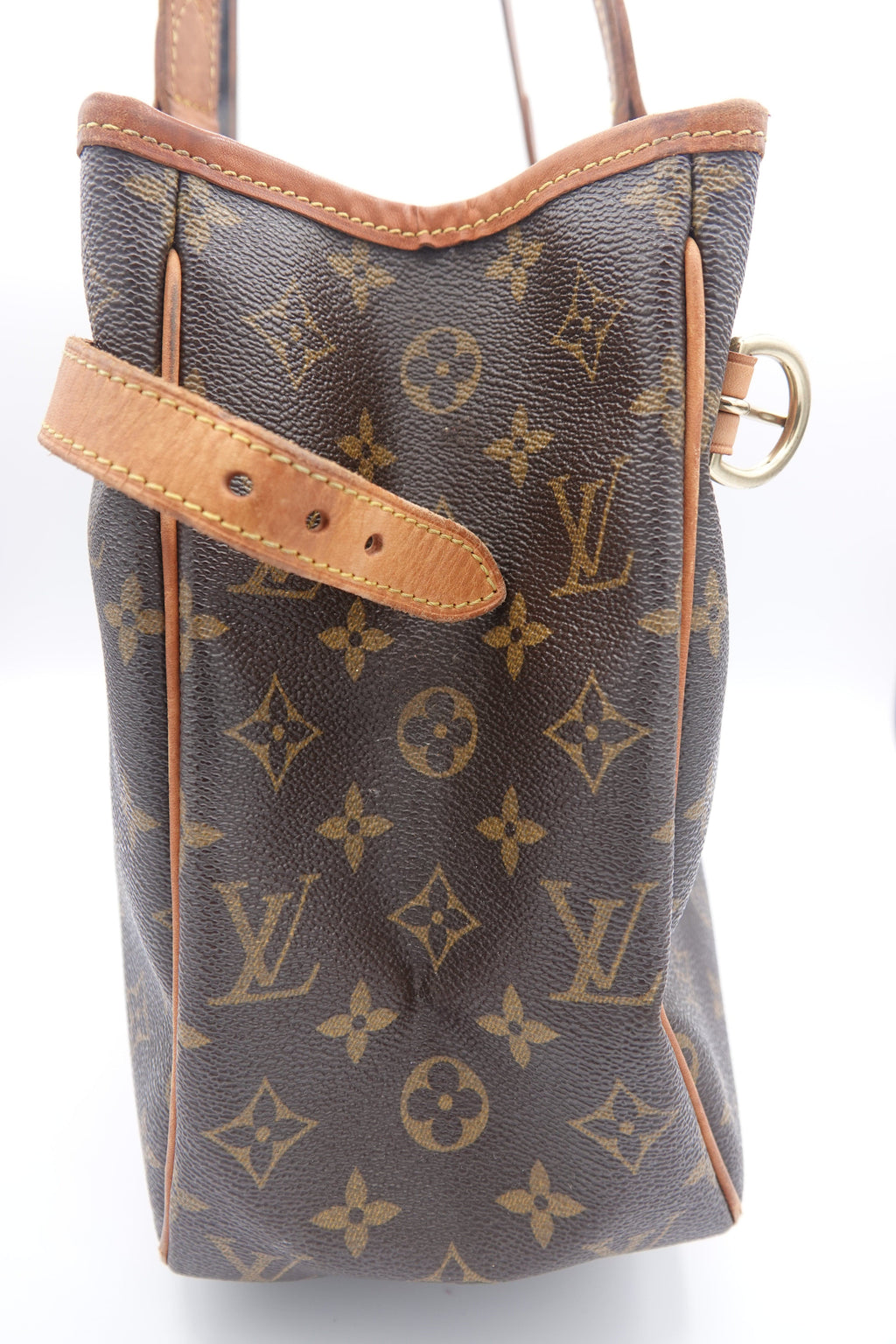 Brown monogram handbag with tan leather handle on a white background