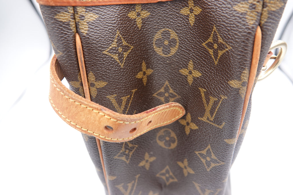 Close-up of a brown leather handbag with a prominent logo pattern on a white background